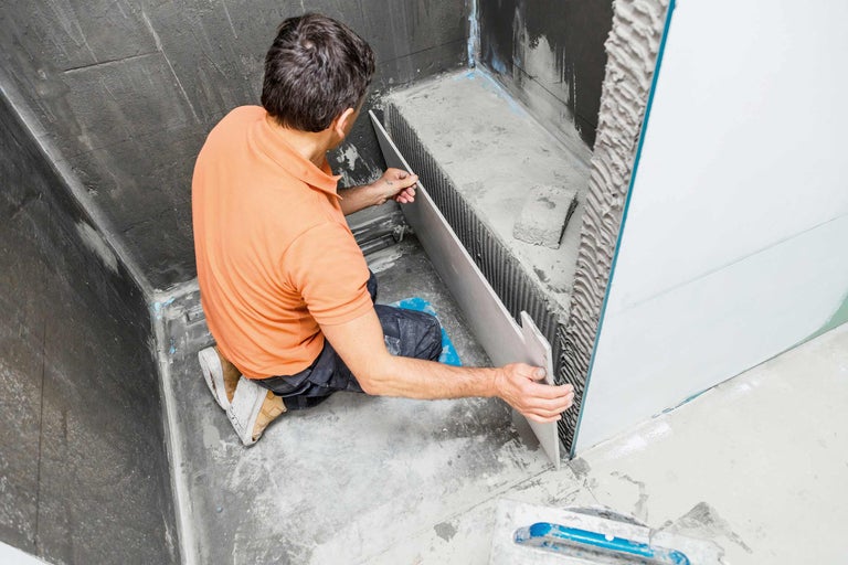 Carreleur au travail dans la salle de bain.