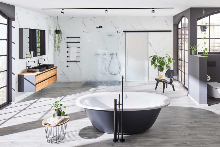 Salle de bains lumineuse avec baignoire îlot, meuble-lavabo avec deux vasques, douche à l'italienne et mur en marbre