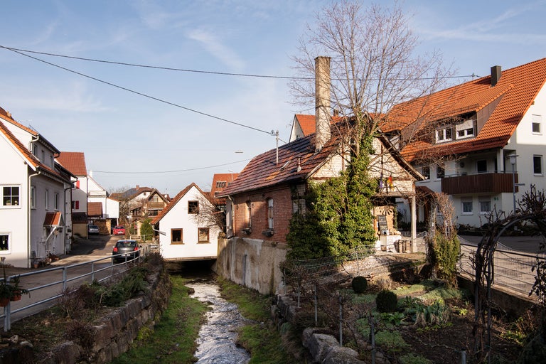Dorfansicht mit Häusern und Bachlauf