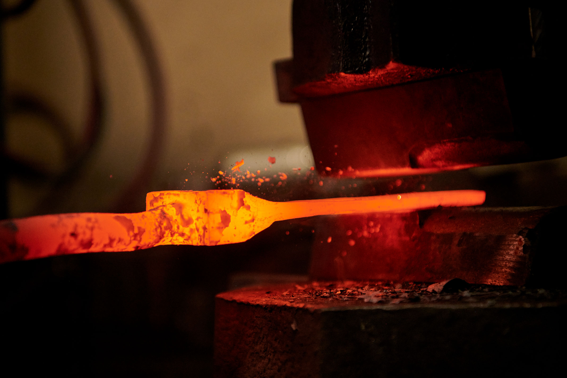 Glühendes Metallstück in einer Schmiedepresse