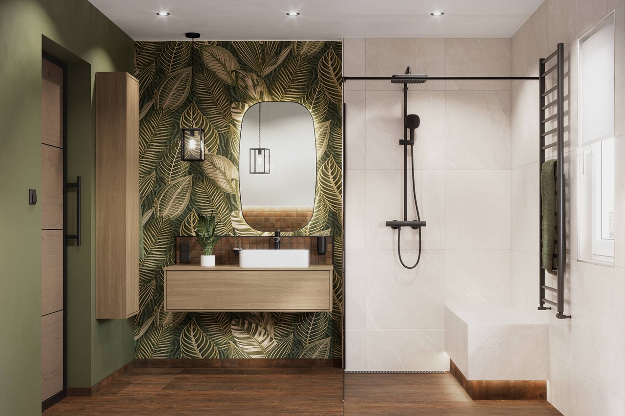 Salle de bains moderne avec papier peint à feuilles tropicales, meuble sous-vasque en bois, douche à l'italienne, robinetterie noire et carrelage.