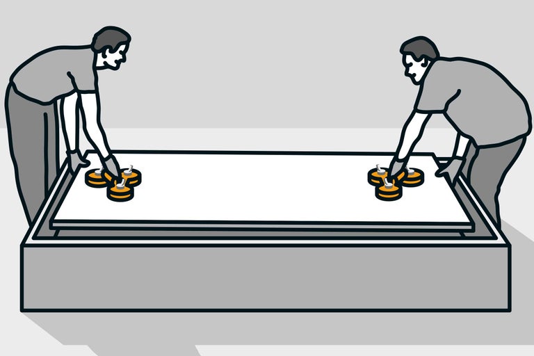 Zwei Personen transportieren mit Saughebern eine Fliese.