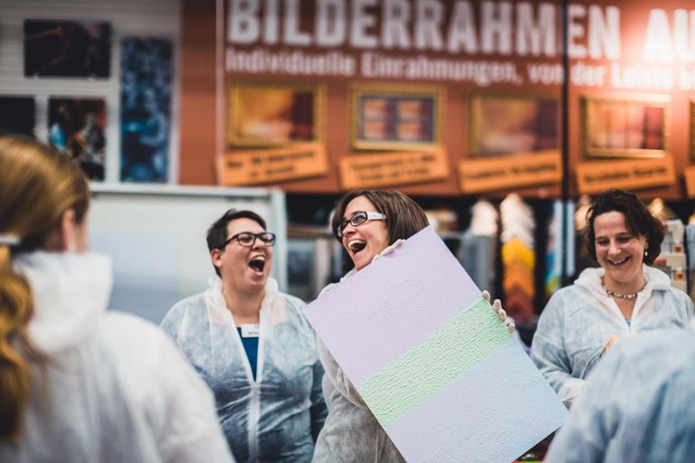 Des personnes regardant une plaque peinte avec différentes textures