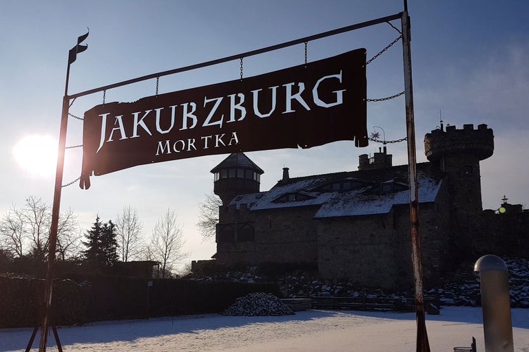 Jakubzburg Mortka Schild vor einem Schloss im Winter