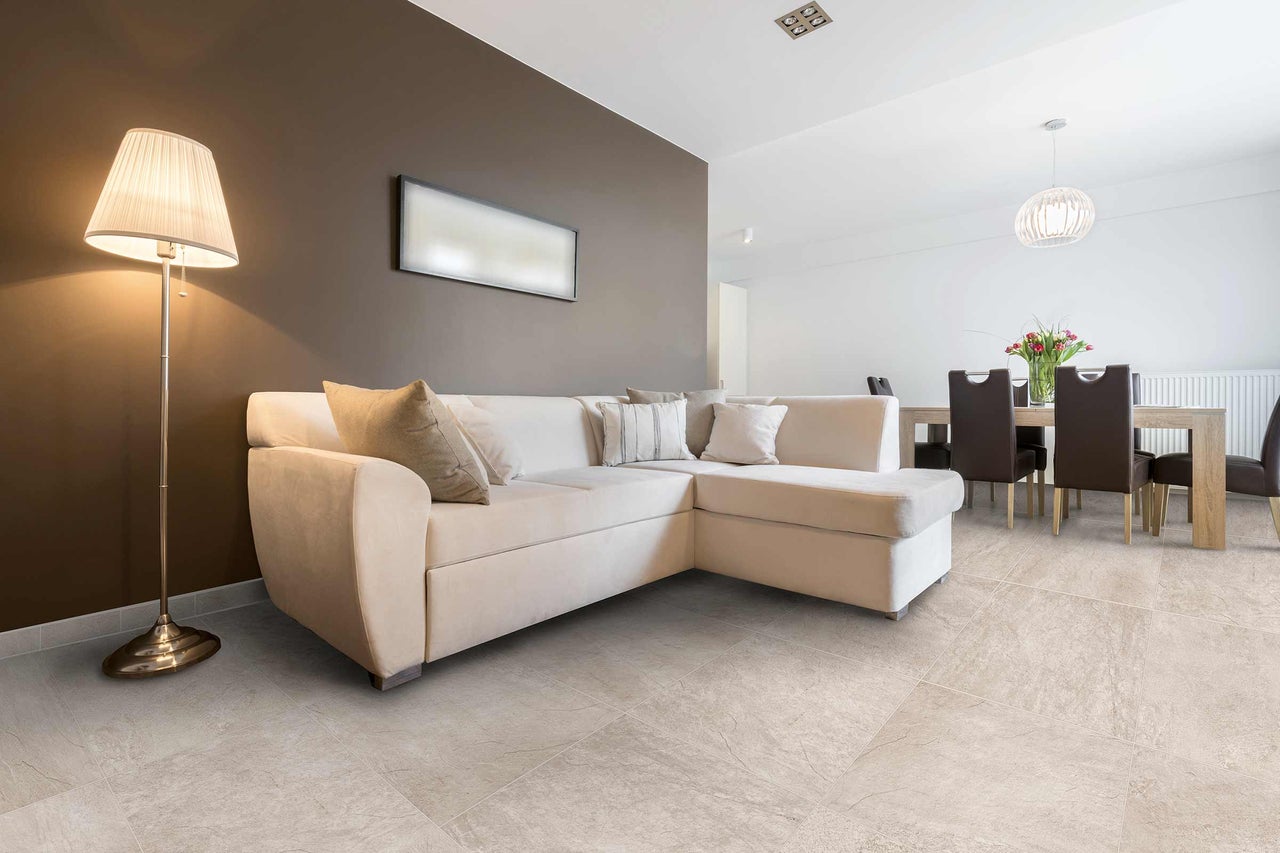Séjour avec canapé d'angle, lampadaire et carrelage