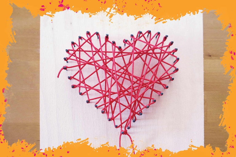 Art du fil en forme de cœur avec des fils rouges sur bois