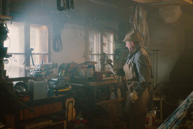 Werkstatt mit Mann in Arbeitskleidung und Werkzeugen