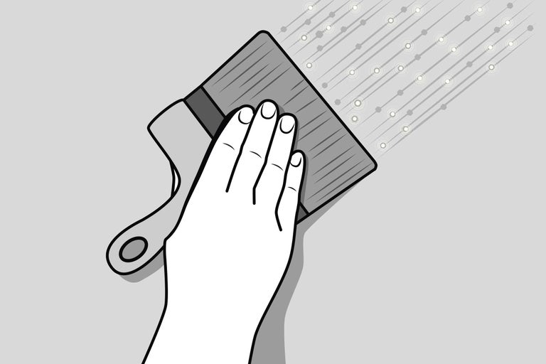 Eine Hand hält eine Bürste beim Auftragen von Farbe auf eine Oberfläche