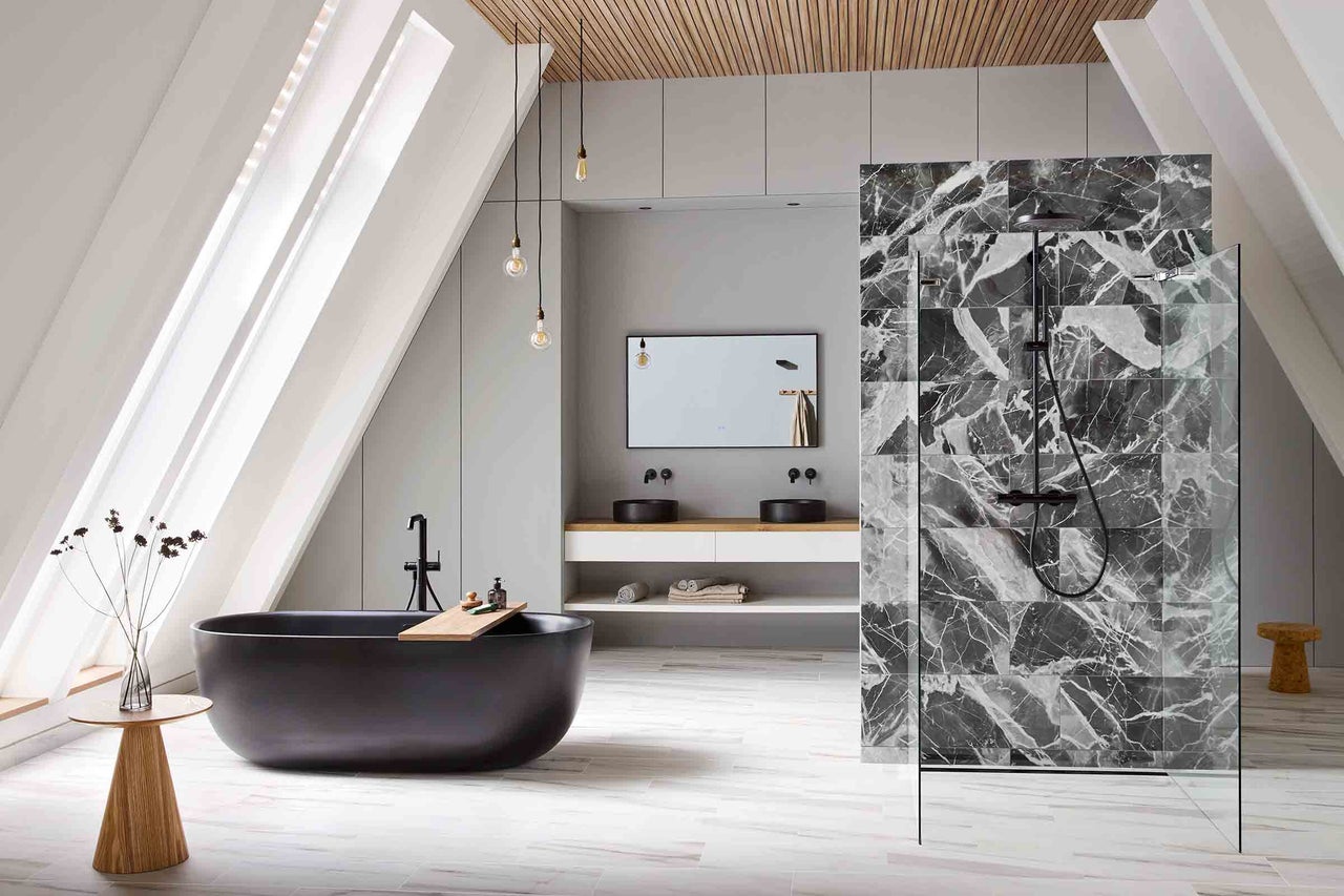 Salle de bains lumineuse avec baignoire, douche et lavabo sous les combles