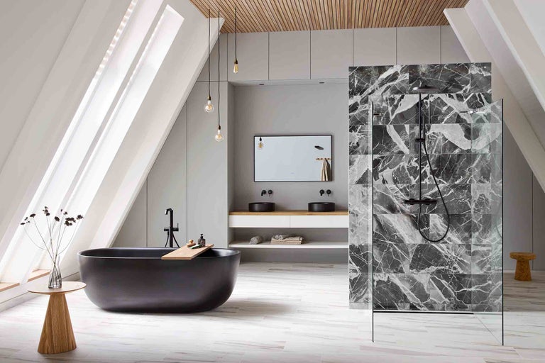 Salle de bains lumineuse avec baignoire, douche et lavabo sous les combles