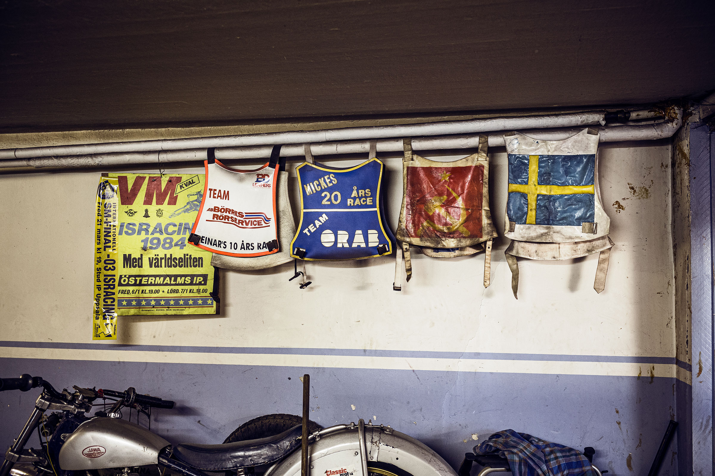 Mur avec des souvenirs de courses de moto : affiches, numéros de départ
