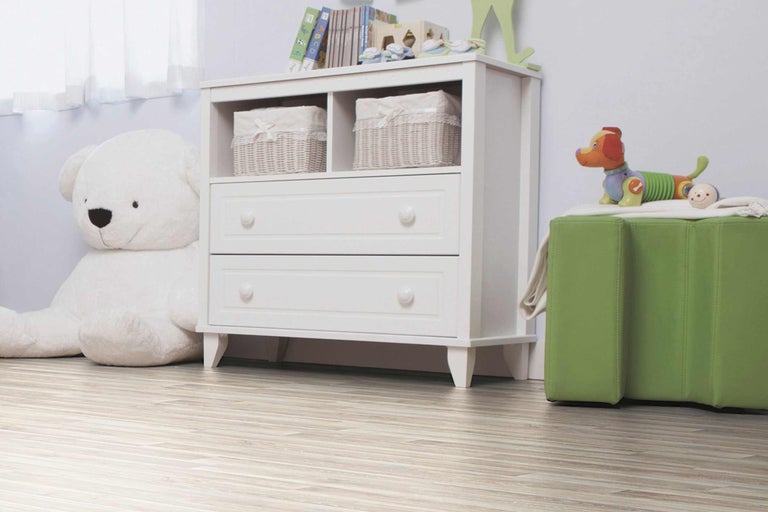 Kinderzimmer mit weißer Kommode, Spielzeug und Holzboden