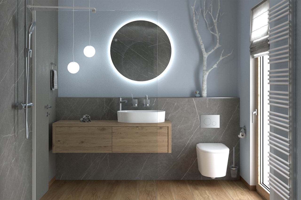 Salle de bains moderne avec meuble sous vasque en bois, miroir rond à LED, vasque à poser, WC suspendu et douche.