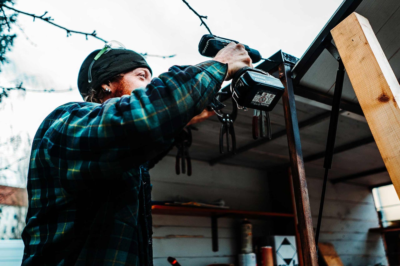 Un artisan travaille avec une visseuse sans fil sur un projet de construction.