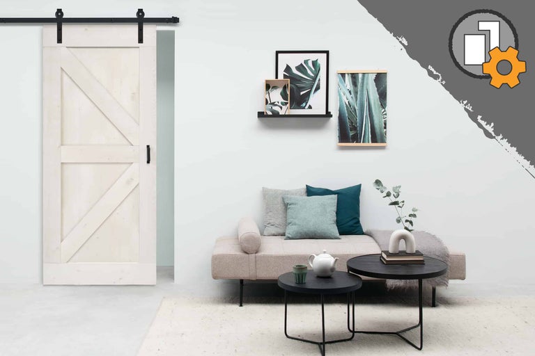 Salon avec porte coulissante style grange, canapé, tables basses et décoration