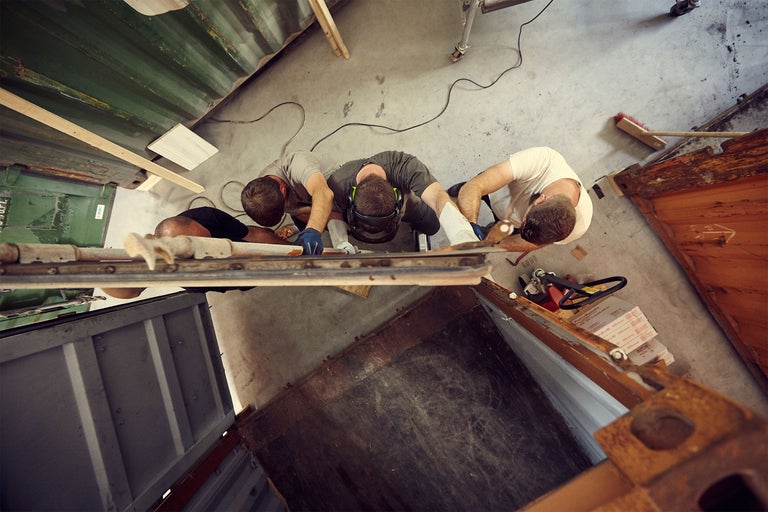 Draufsicht von drei Handwerkern, die an einem Bauprojekt arbeiten