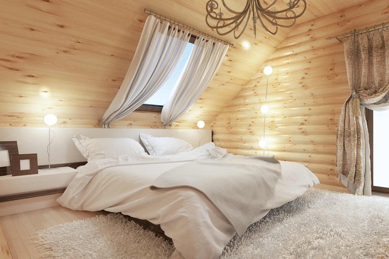 Chambre lumineuse avec murs en bois, lit double, table de chevet et rideaux
