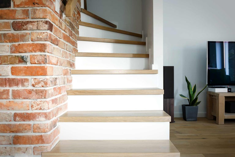 Escalier avec marches en bois et mur de briques