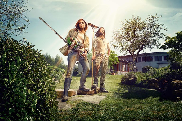 Deux personnes avec des outils de jardin dans un jardin.
