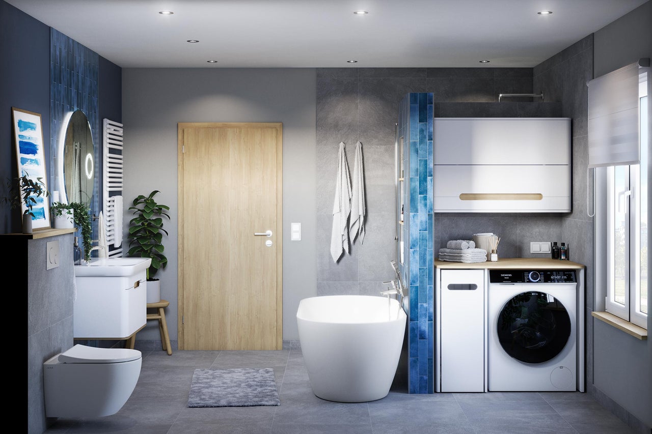 Salle de bain avec baignoire, lavabo, WC, machine à laver et détails en bois pour une ambiance lumineuse et organisée.