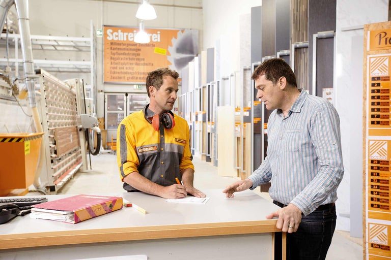 Ein Hornbach Mitarbeiter berät einen Kunden an einem Tresen