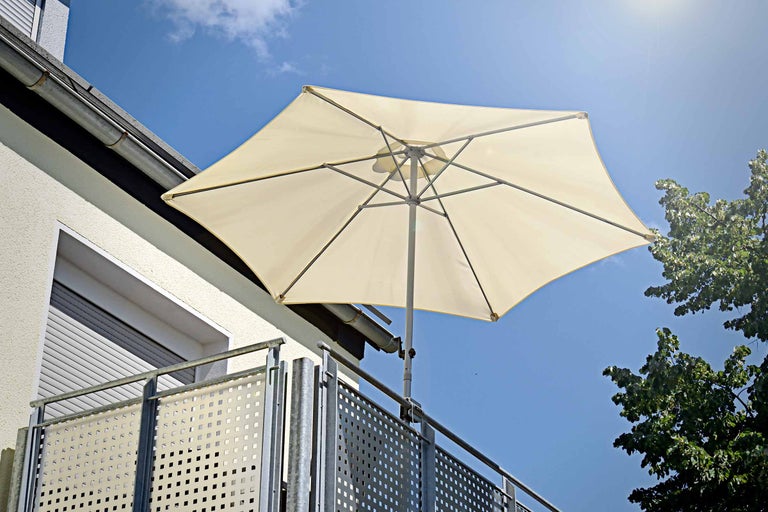 Parasol de balcon ouvert avec fixation à la balustrade sur fond de ciel bleu