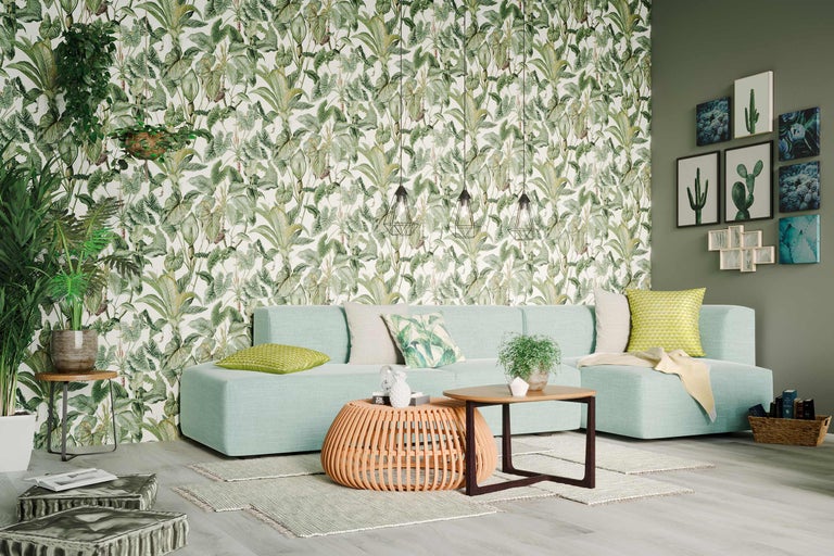 Salon avec canapé, table, plantes et papier peint à motifs végétaux