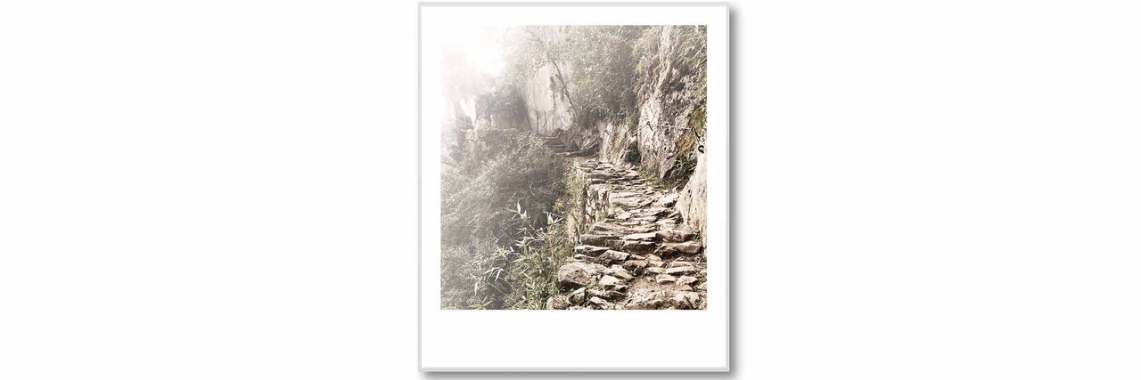Image encadrée d'un sentier en pierre le long d'une montagne