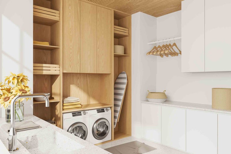Buanderie lumineuse avec lave-linge, sèche-linge, étagères et planche à repasser