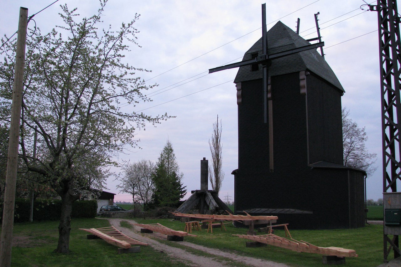 Moulin à vent historique avec des constructions en bois sur une pelouse