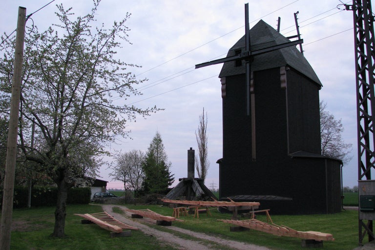 Moulin à vent historique avec des constructions en bois sur une pelouse