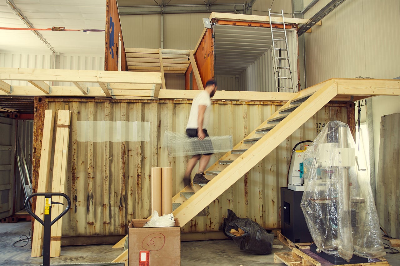 Scène avec un homme montant un escalier fixé à un conteneur.