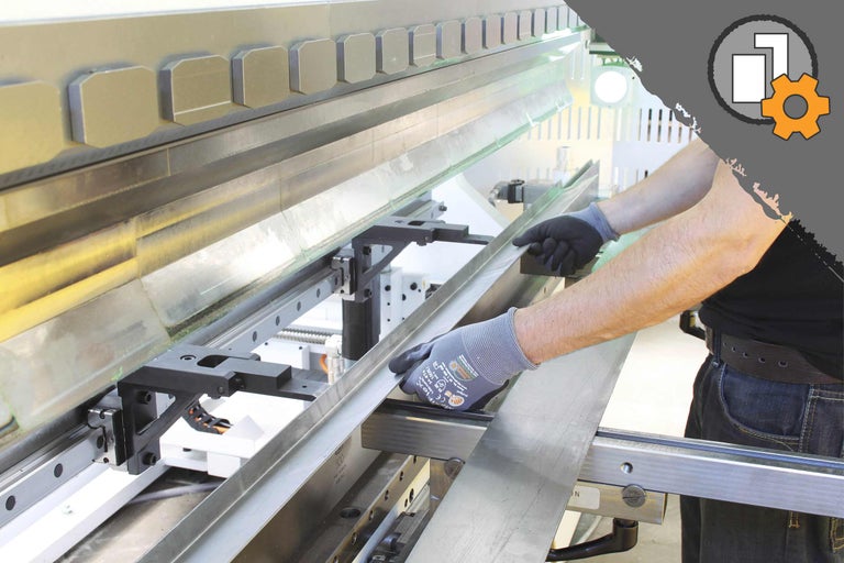 Une presse plieuse en action avec une personne pliant une tôle.