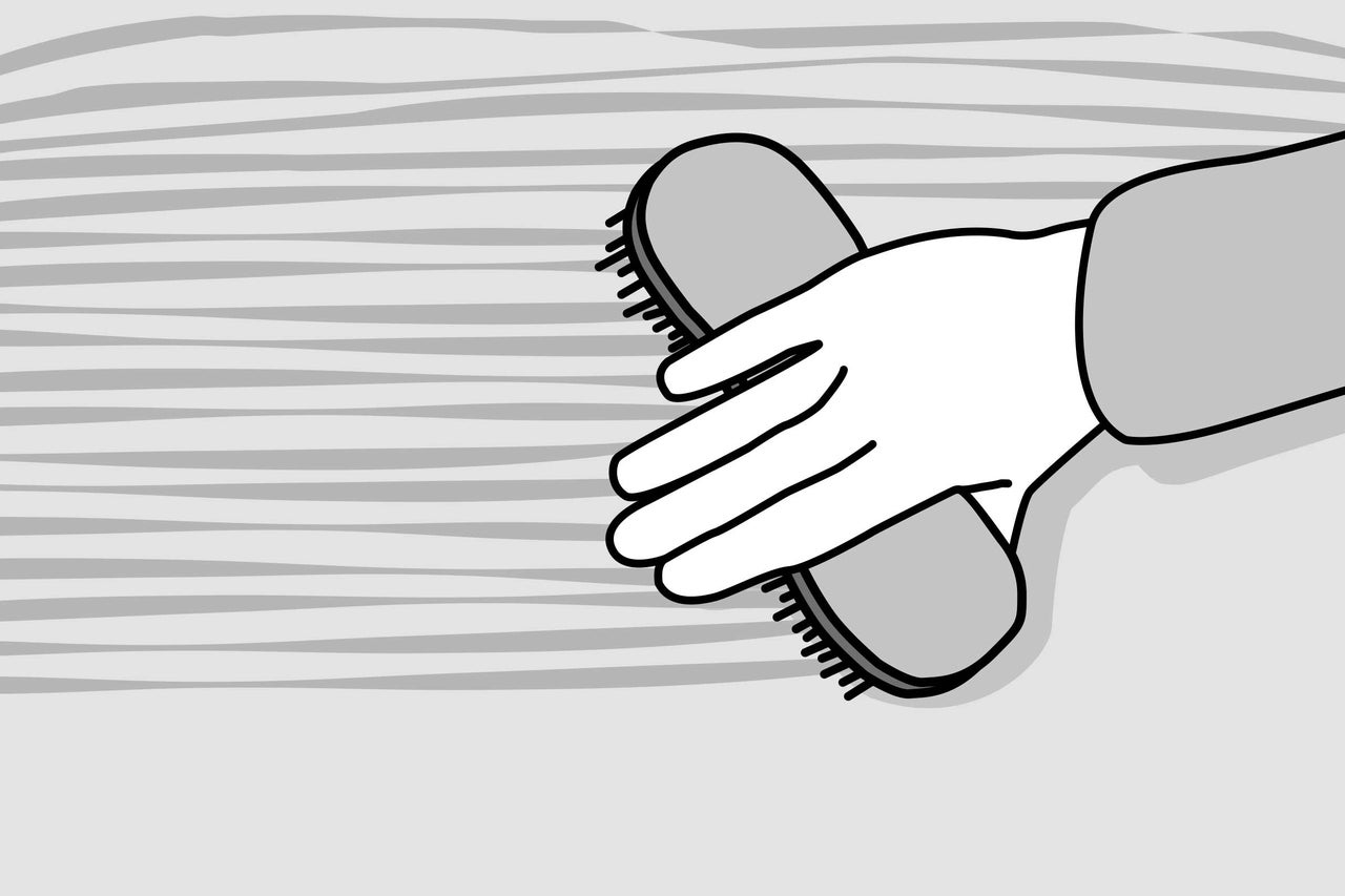 Main avec brosse pour nettoyer les surfaces