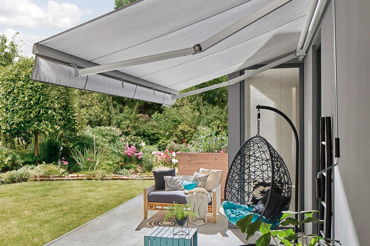 Terrasse avec store, coin salon et fauteuil suspendu