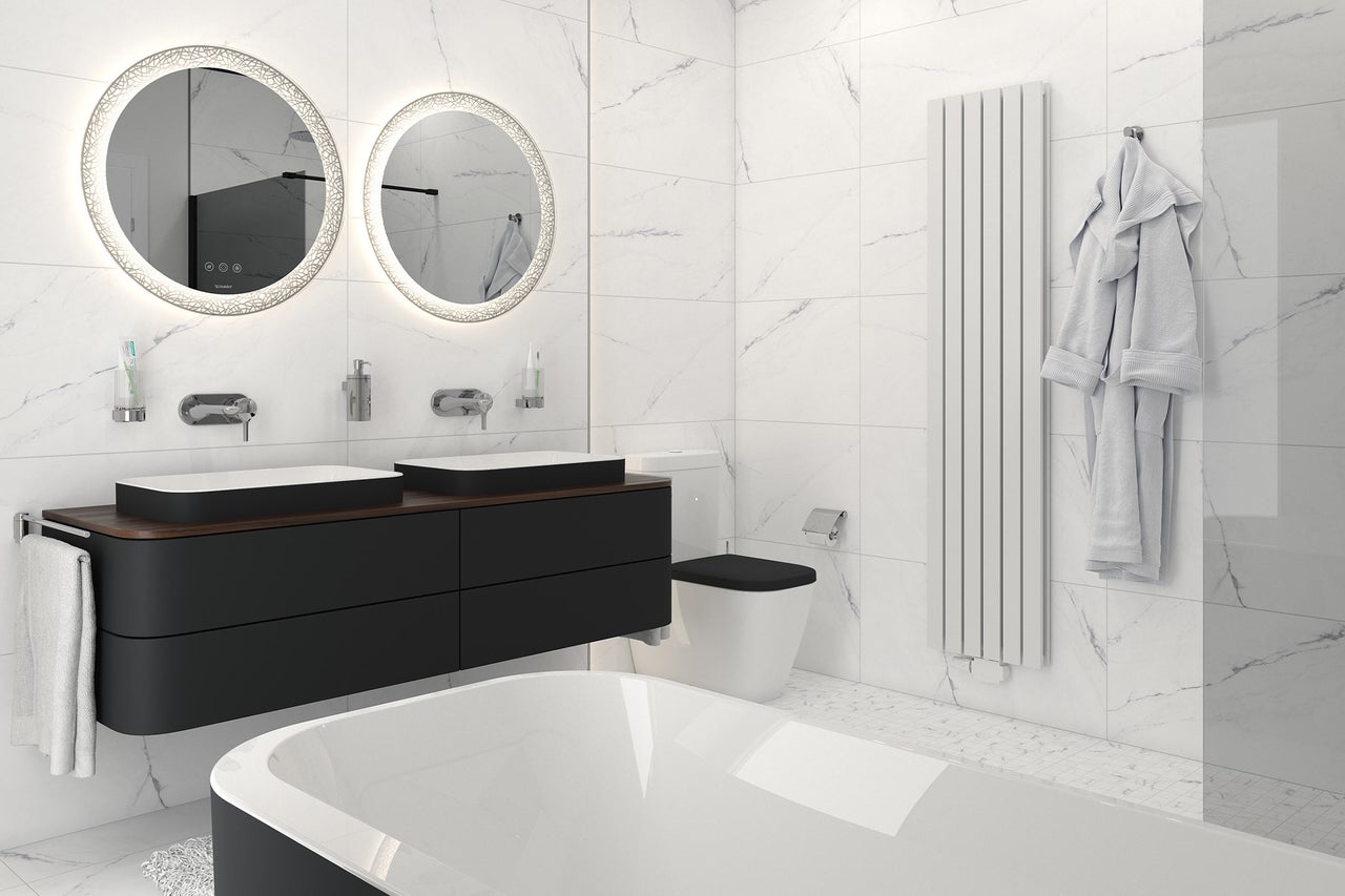 Salle de bain moderne avec double vasque, miroirs ronds avec éclairage, radiateur et baignoire.