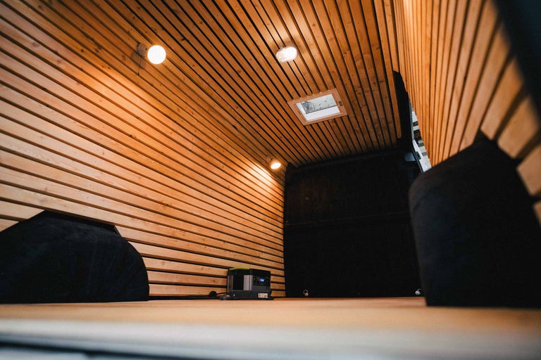 Innenraum eines Transporters mit Holzverkleidung, Fenster und Beleuchtung