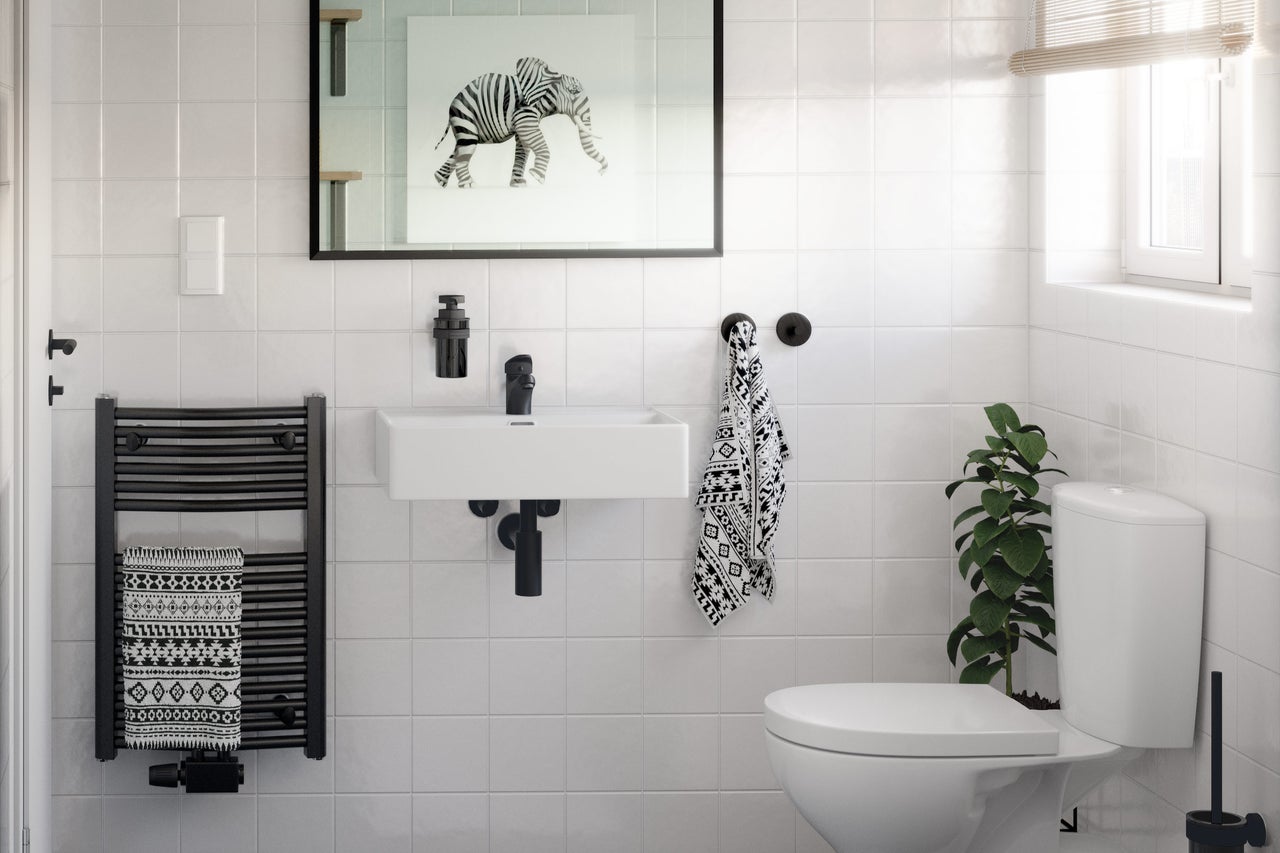 Helles Badezimmer mit Waschbecken, Toilette, Handtuchwärmer und Dekorationen