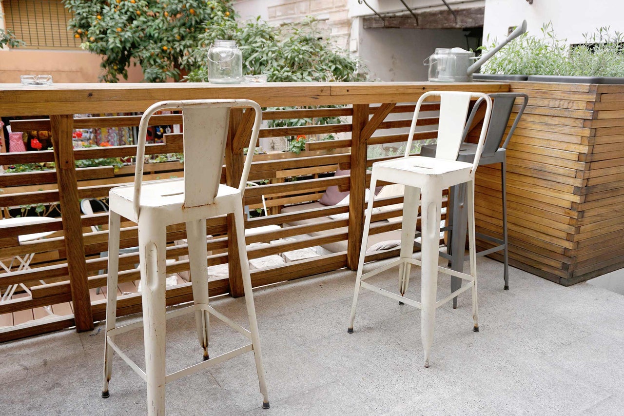 Espace extérieur avec tabourets de bar en métal et table en bois