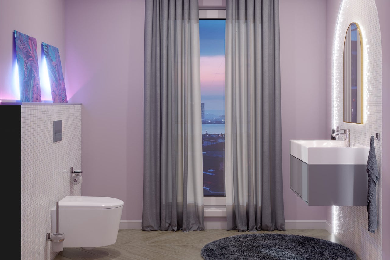 Salle de bains moderne avec toilette suspendue, meuble sous-vasque, miroir éclairé et fenêtre avec rideaux.