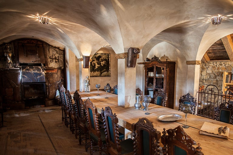 Langer Holztisch mit Stühlen in einem Raum mit gewölbter Decke