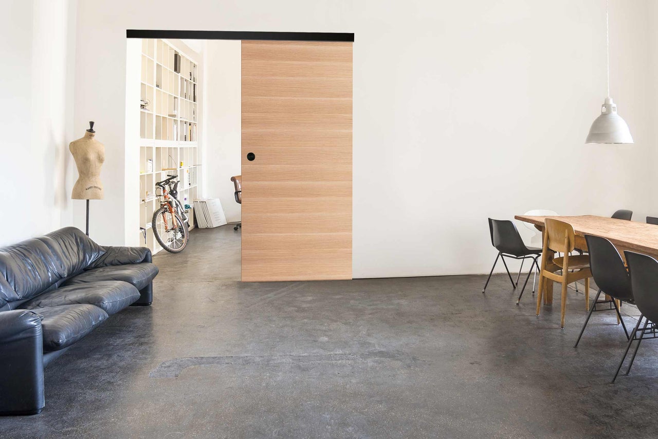 Espace de vie lumineux avec porte coulissante, table à manger et canapé.