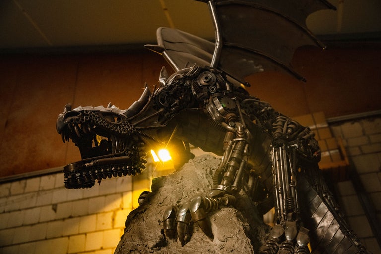 Drachenskulptur aus Metall auf einem Steinsockel