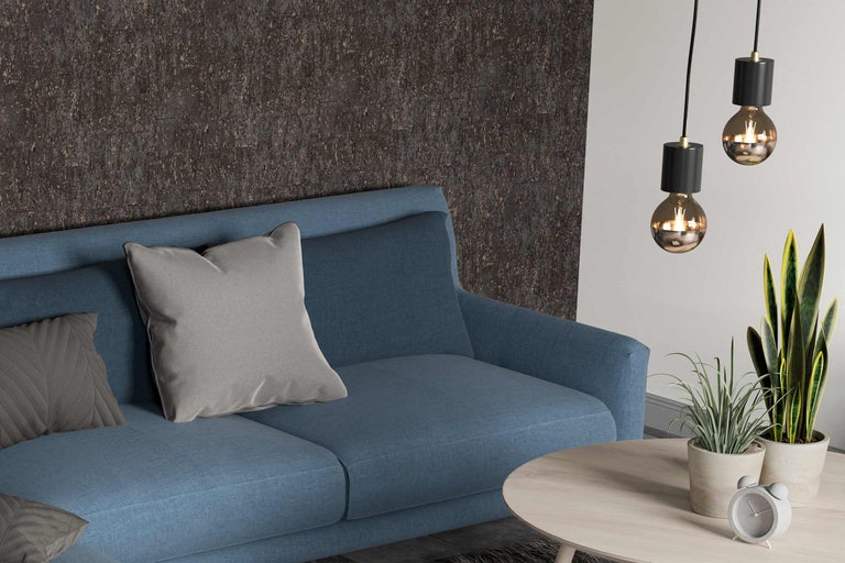 Wohnzimmer mit blauem Sofa, Kissen, Couchtisch, Zimmerpflanzen und Pendelleuchten