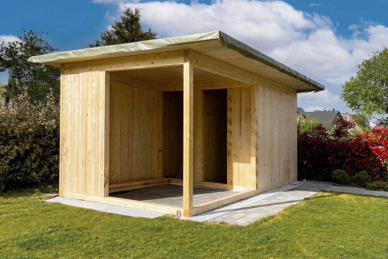 Abri de jardin moderne en bois naturel avec toit plat et auvent ouvert dans un jardin.