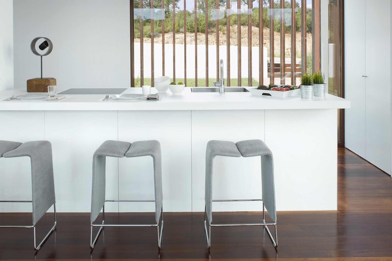 Moderne Küche mit Barhockern, Spüle und Dekoration auf der Arbeitsplatte