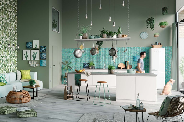 Cuisine d'habitation lumineuse et spacieuse avec îlot de cuisine, tabourets de bar, plantes suspendues et décorations