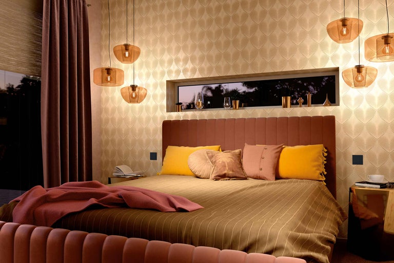 Schlafzimmer mit Bett, Nachttischen und Pendelleuchten