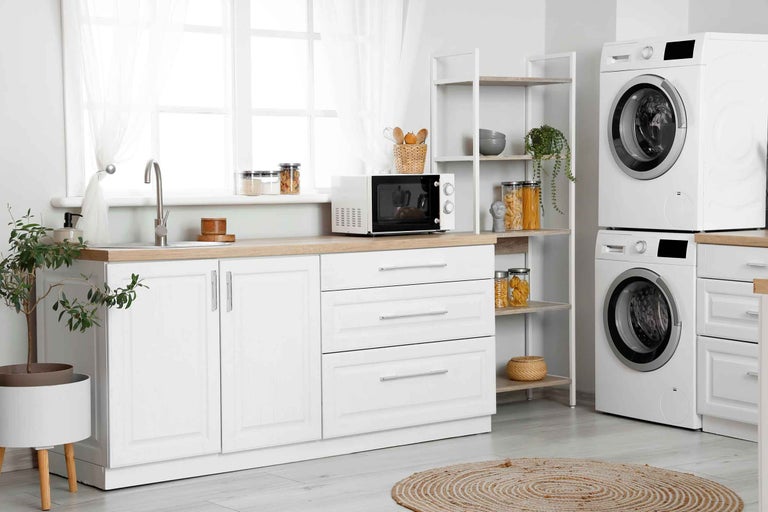 Pièce lumineuse avec machine à laver, sèche-linge, micro-ondes, étagère et kitchenette