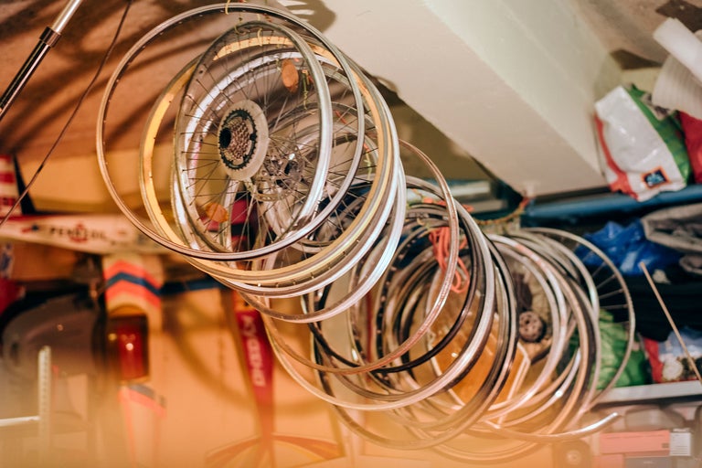 Plusieurs jantes de vélo suspendues au plafond d'une pièce.